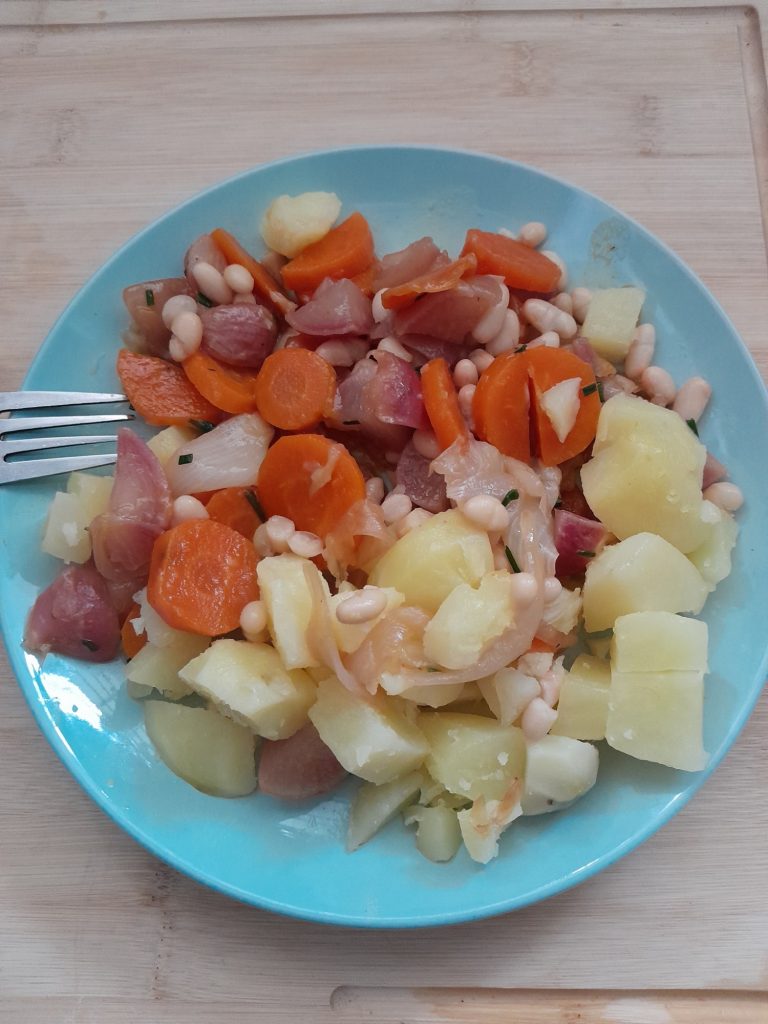 Assiette de confit de radis et carottes au miel, avec haricots blancs, pommes de terre vapeur et ciboulette