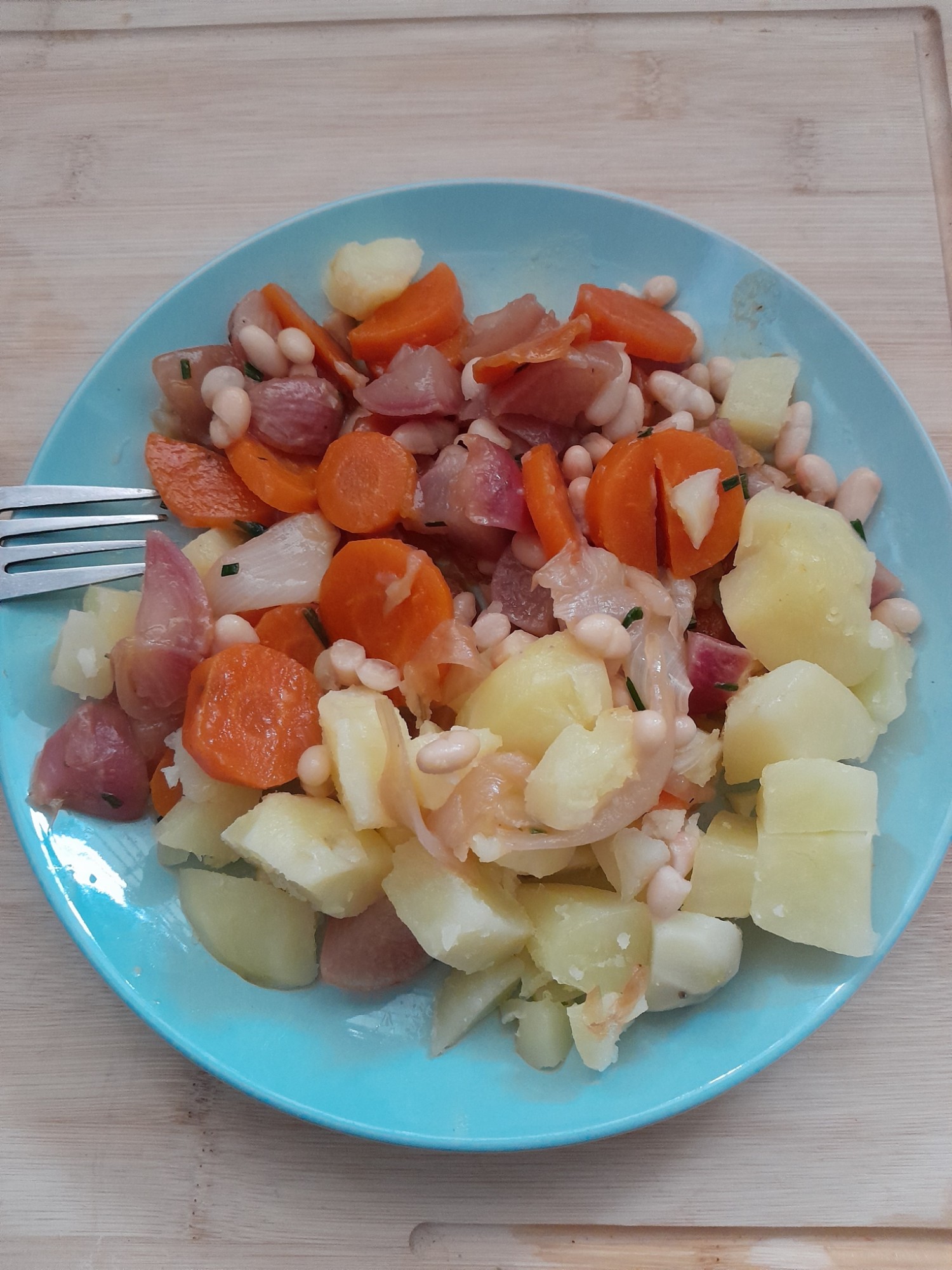 Assiette de confit de radis et carottes au miel, avec haricots blancs, pommes de terre vapeur et ciboulette